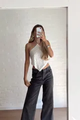 Top blanco con textura, escote halter y espalda descubierta.