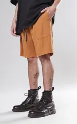 Bermuda de corte regular color tabaco, confeccionada en tejido de algodón con textura tipo lino. Presenta cintura elástica con cordón ajustable con detalle de marca bordada y dos bolsillos delanteros.