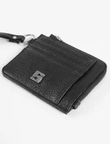 Tarjetero amarillo de cuero vegano con textura granulada, cierre superior con cremallera, tres ranuras para tarjetas y correa de muñeca.