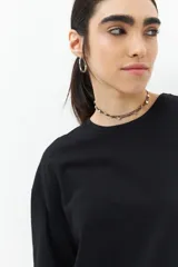 Remera blanca de algodón con cordones ajustables a los laterales, manga corta y cuello redondo.