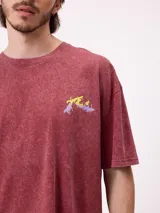 Remera de algodón con calce oversize, color negro con efecto lavado. Presenta un estampado gráfico en la espalda con diseño de espiral en tonos rosado y celeste, acompañado de inscripciones decorativas.