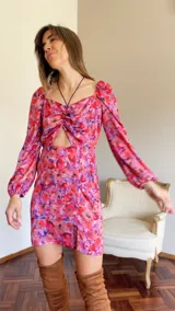 Vestido corto rojizo con estampado floral, escote fruncido con abertura, mangas largas abullonadas y falda con tajo lateral.