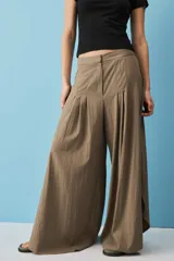 Pantalón marrón de corte ancho y fluido, con pinzas frontales y tiro alto.