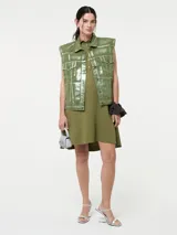 Chaleco denim rosa con efecto metalizado plateado, sin mangas y con cierre de botones.