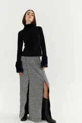 Falda midi de corte recto con estampado de pata de gallo en blanco y negro. Presenta dos tajos frontales con cierre y cierre trasero invisible.