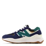 Championes urbanos New Balance, color azul marino, negro y verde, con cordones blancos y suela marrón.