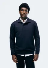 Buzo negro de algodón con cuello tipo polo y manga larga.