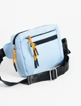 Riñonera color beige, con dos compartimentos con cierre y tiracierres con cordón negro y naranja. Correa regulable de tela negra.