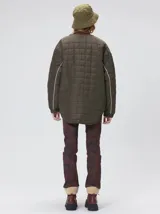 Campera reversible capitoneada con cierre frontal. Un lado es de color negro y el otro es de color beige, ambos con diseño acolchado. Cuenta con cuello redondo, mangas largas y bolsillos laterales.