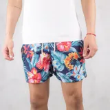 Short de baño azul marino con estampado de flores rojas, naranjas y celestes.