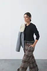 Sweater de tejido tipo rib, color negro, con cuello redondo y mangas largas. Presenta una textura acanalada y un ajuste al cuerpo.
