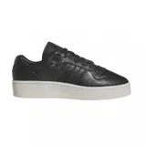 Championes adidas Rivalry Lux Low de cuero negro con textura granulada, diseño de caña baja y suela de plataforma en color blanco hueso.