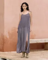 Vestido largo color gris con tirantes finos ajustables, cuerpo con plisado fino, escote en V con detalle tejido a crochet e hilera de pequeños botones en el lateral. Falda amplia y fluida con abertura lateral.