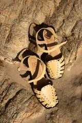 Sandalias cangrejeras color rojo con detalles de tachas doradas y correa con hebilla al tobillo.