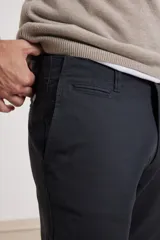 Pantalón chino de hombre color verde oscuro, corte slim, confeccionado en algodón con elastano, con triple pespunte en las costuras y botones al tono.