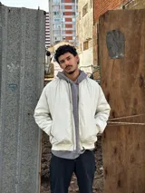 Campera bomber color crudo de nylon con cierre frontal y bolsillos laterales.