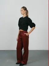 Pantalón de corte recto y tiro alto, confeccionado en pana color bordó. Presenta cierre frontal con botón y bolsillos laterales.