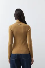 Polera de manga larga y cuello alto, confeccionada en tejido de punto fino, con un ajuste ceñido al cuerpo.