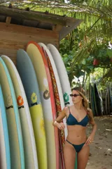 Top de bikini negro con copas triangulares, breteles finos regulables con detalle de cuentas y cierre trasero con gancho.