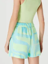 Short de tiro alto con diseño estampado geométrico en tonos verde y turquesa, cuenta con bolsillos laterales y cierre frontal.