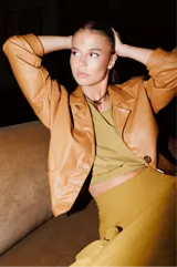 Top color verde pistacho, con escote redondo amplio, mangas cortas con efecto hombreras y espalda descubierta.