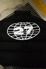 Campera puffer negra con capucha y cierre frontal. Tiene un logo estampado en el pecho.