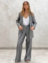 Pantalón celeste de lino con corte palazzo y detalle de costuras verticales en color blanco.