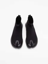 Bota negra tipo pezuña marca Tabi, con capellada de tejido Tencel y suela de caña de azúcar.