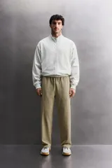 Pantalón jogger de corte relajado confeccionado en tejido compacto de algodón. Presenta cintura elástica con cordón interior, bolsillos frontales en la cadera y un bolsillo trasero de plastrón.