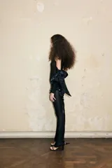 Mono largo negro de un solo hombro con mangas caídas. Un lado tiene un lazo drapeado cosido al costado de la cadera que se puede cruzar de varias maneras.