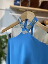 Vestido rojo de corte suelto, con cuello halter y espalda descubierta.