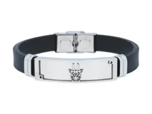 Pulsera de goma negra con apliques de acero plateado y cierre de hebilla. Presenta un dije central con el diseño de una mano de Hamsa.