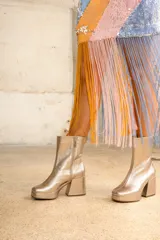 Botas de cuero vacuno color dorado con plataforma y taco acampanado. Cierre lateral.