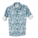 Camisa celeste con estampado de hojas blancas, de manga larga con puños enrollados y cuello clásico.