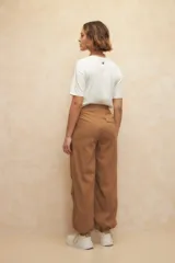 Pantalón babucha tipo parachute color beige, de nylon, con cordones ajustables en la cintura y en los tobillos.