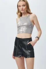 Short negro de cuero sintético con bolsillos laterales y cierres metálicos decorativos en el frente.