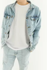 Campera de jean celeste claro con cuello clásico, cierre frontal con botones metálicos, bolsillos con solapa abotonada en el pecho y bolsillos laterales.