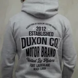 Canguro gris con capucha y cordones negros, bolsillo tipo canguro y estampa en el pecho con el texto "Duxon Co Motor Brand".