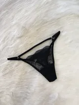 Tanga de encaje negro con diseño regulable, tiras finas elásticas y entrepierna de algodón.