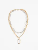 Collar doble con cadena dorada y plateada, con dije ovalado dorado.