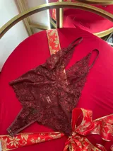 Body de encaje color bordó con breteles regulables y escote pronunciado.