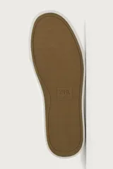 Zapatilla de estilo minimalista con cordones, confeccionada en material sintético de acabado mate. Presenta una horma redonda, forro interior en tono contrastante y suela de goma con textura ligera.
