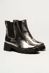 Bota tipo Chelsea de cuero color verde oliva, con paneles laterales elásticos negros y suela track de goma negra con taco cuadrado.