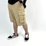 Bermuda de jean color beige con lavado gastado, corte recto y bolsillos cargo laterales.