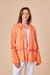 Chaqueta color naranja de lino con capucha y cordón ajustable. Presenta apliques de puntilla en mangas y ruedo.