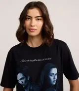 Remera negra de algodón con cuello redondo y manga corta. Presenta un estampado frontal de los personajes principales de la saga Crepúsculo (Bella y Edward) en tonos azules y la palabra "twilight" en la parte inferior.