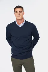 Suéter de tejido fino color azul marino, con cuello en V y manga larga. Presenta un pequeño logo bordado en el pecho.