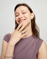 Anillo plateado en forma de ojo con cristal facetado azul.