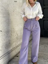 Pantalón wide leg de jean color lila, con tiro alto, pinzas en la pretina y elástico en la cintura.