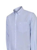 Camisa de vestir de manga larga, color celeste y blanco, con patrón de rayas verticales finas. Presenta cuello button-down y un pequeño logo bordado en el bolsillo del pecho.